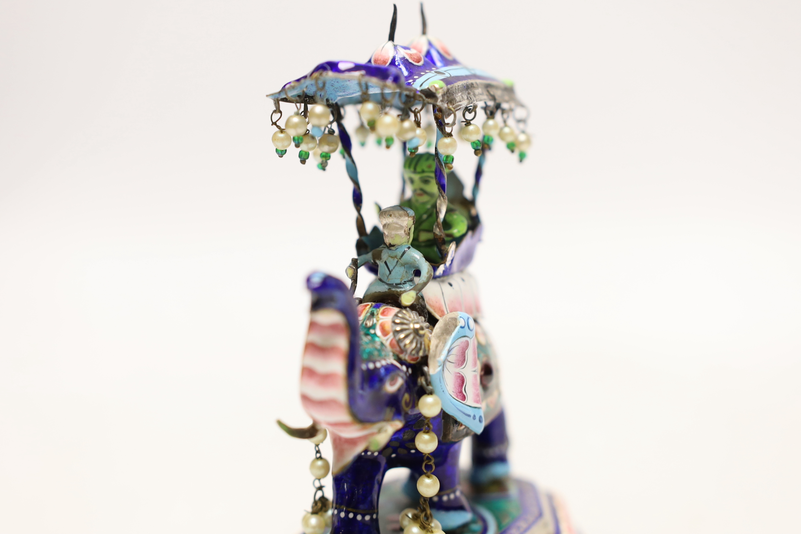 An Indian? white metal, polychrome enamel and gem set model of an elephant with Howdah, on octagonal base, length 96mm.